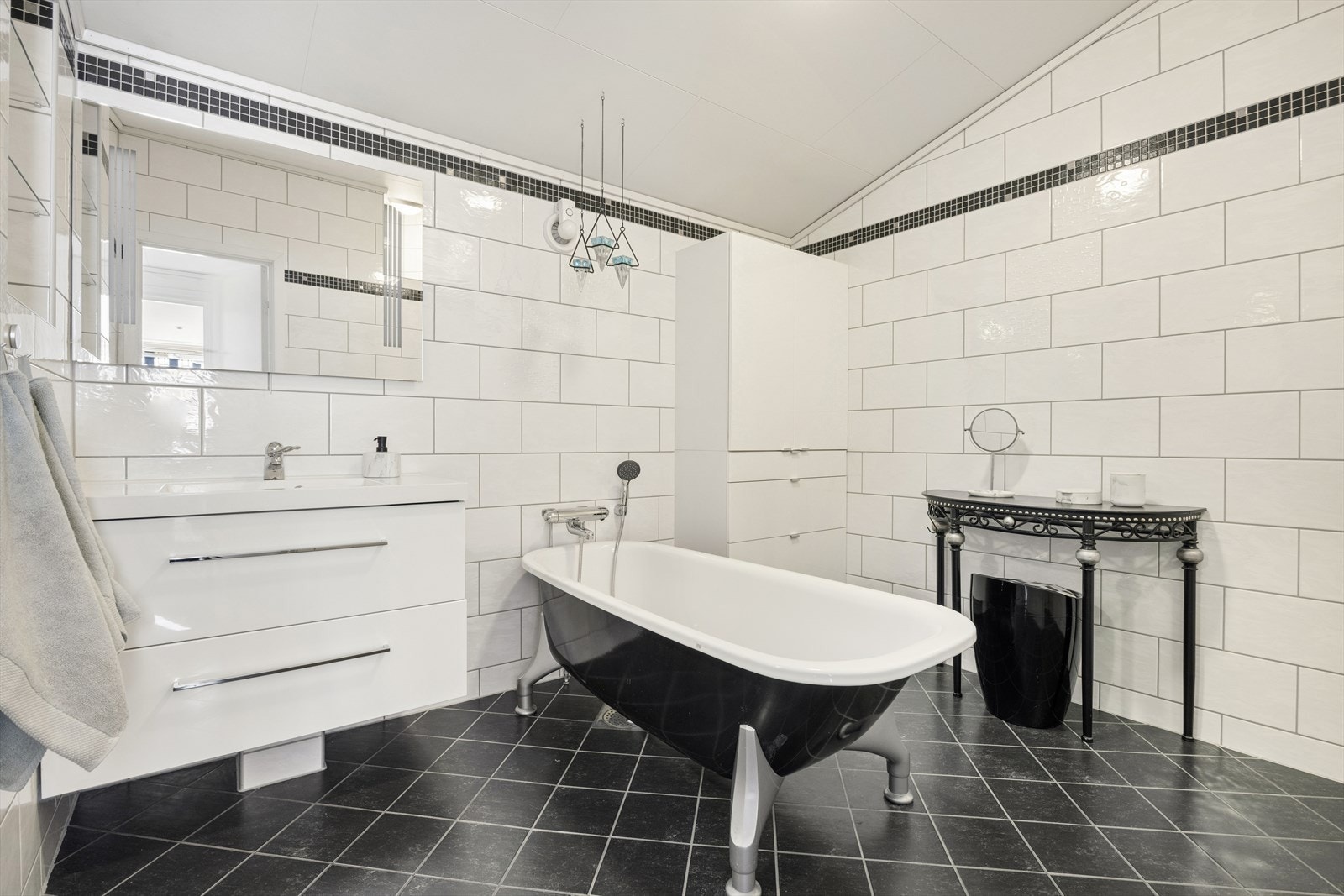 Flislagt bad på ca 8 m² utstyrt med blant annet gulvvarme, badekar, romslig dusjhjørne og servant med oppbevaring. Galleribilde