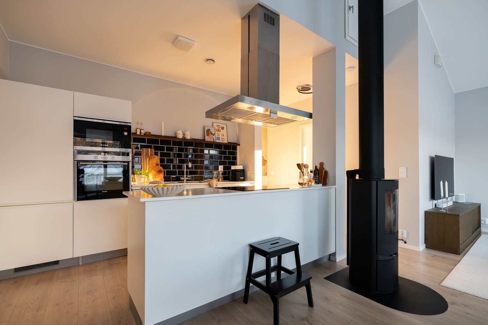 Lys, glatt innredning med laminat benkeplate og nedfelt kum i rustfritt stål. Galleribilde