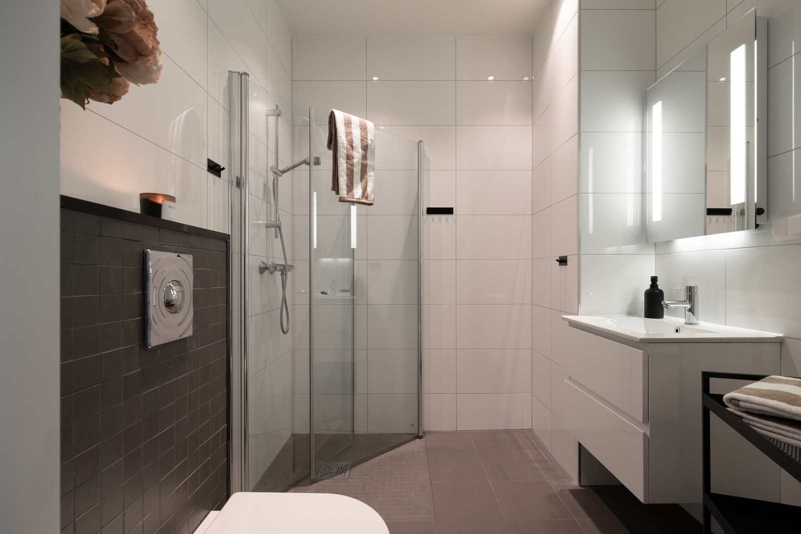 Baderommet fra 2017 er bygget opp med mørke fliser på gulv og lyse fliser på vegger. Rommet har gulvvarme og downlights i himling. Galleribilde