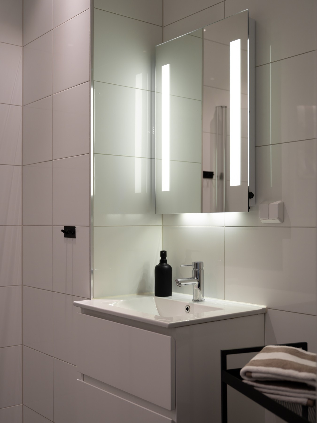 Innredningen består av servant på underskuffer, speil med integrert belysning og vegghengt toalett. Galleribilde