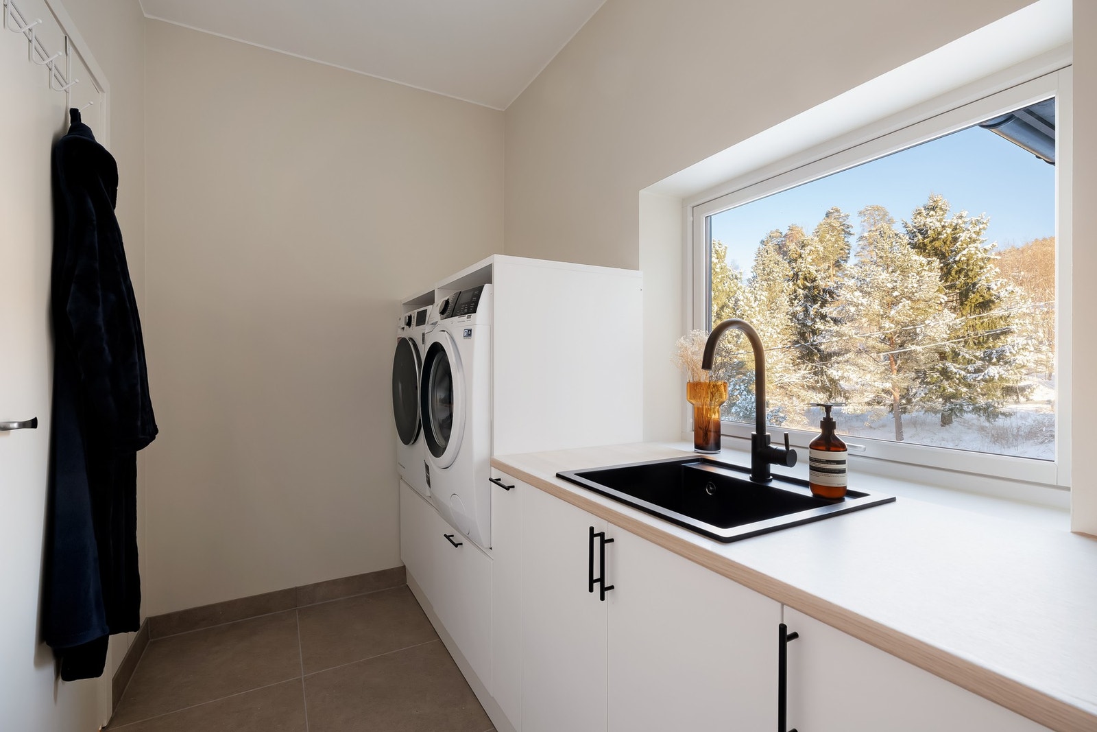 Boligen har et romslig vaskerom med fliser på gulv med varme i samt malte overflater. Galleribilde