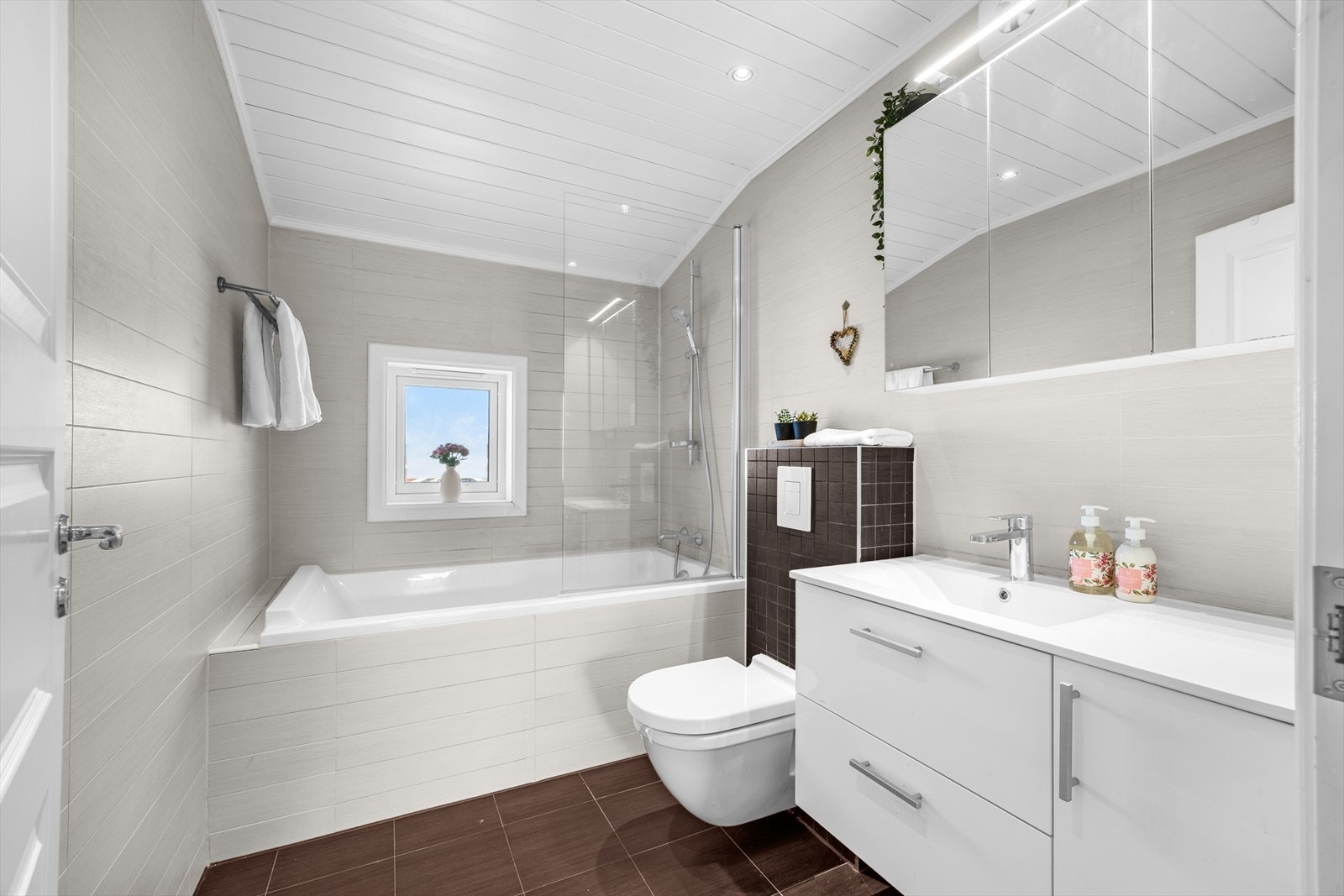 Flislagt baderom fra 2012 med elektriske varmekabler i gulvet og malt panel med innfelte downlights i himlingen. Galleribilde