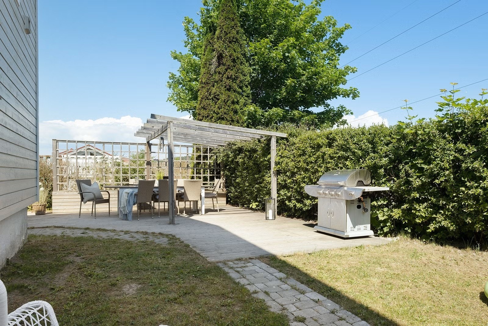 Parsellen er pent opparbeidet med gressplen, belegningsstein og variert beplantning som bidrar til et grønt og trivelig bomiljø. Galleribilde