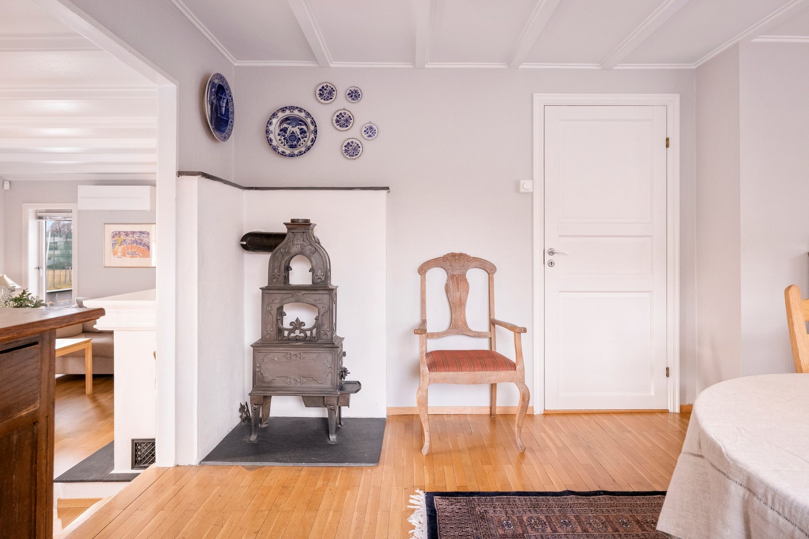 Spisestuen er utstyrt med en eldre etasjeovn som bidrar til både oppvarming og en tradisjonell karakter i rommet. Galleribilde