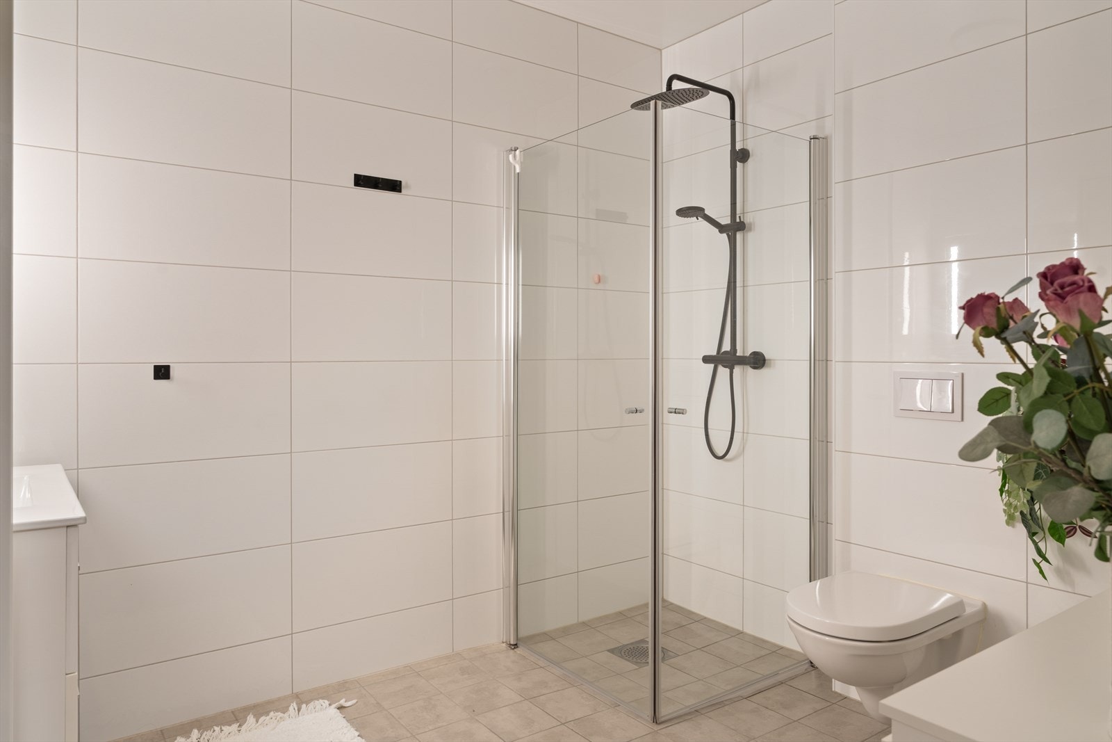 Badet er utstyrt med baderomsinnredning med nedfelt servant, høyskap, vegghengt toalett og dusjvegger Galleribilde