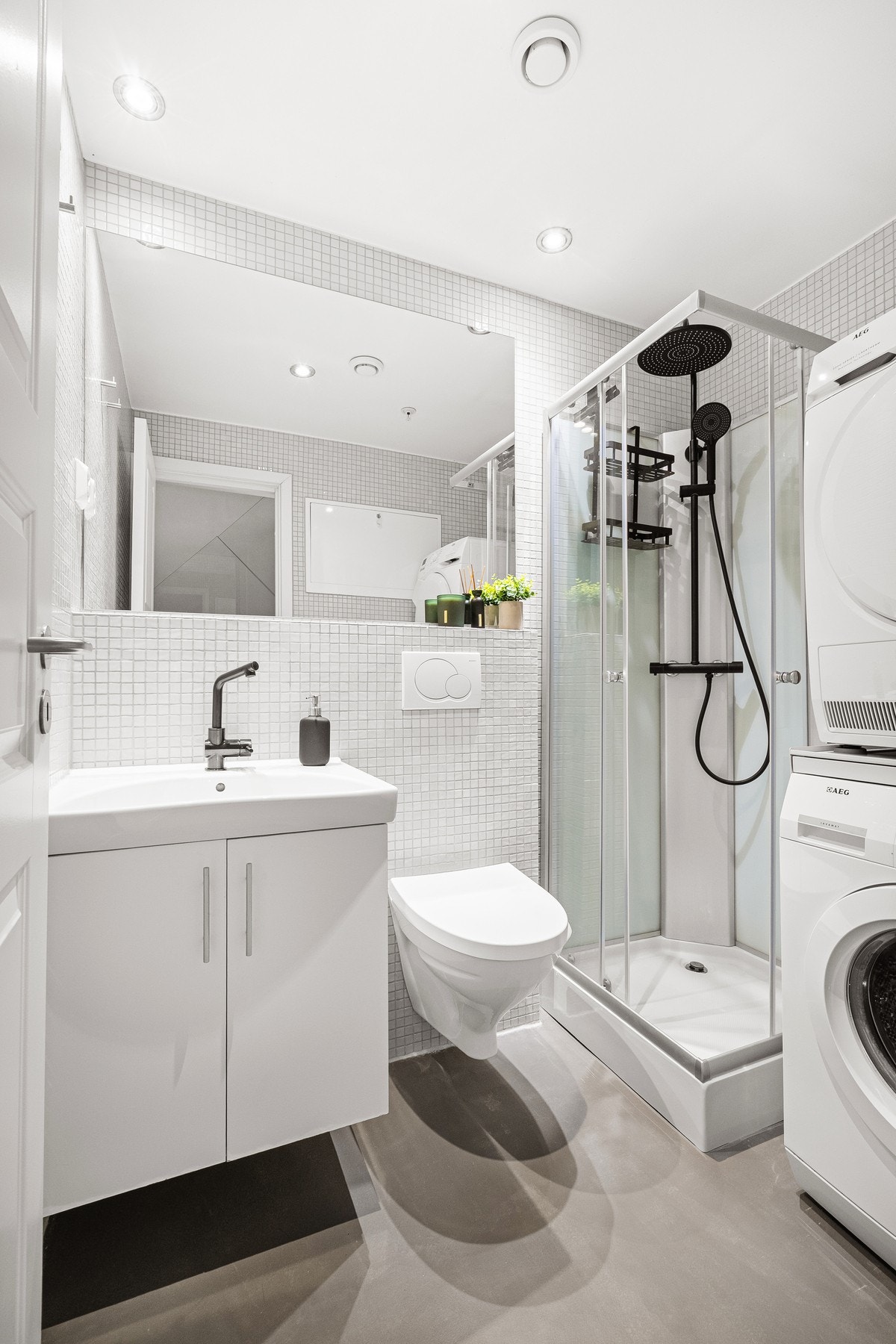 Det er innredet med vegghengt toalett, seksjon med vask, dusjhjørne og opplegg til vaskemaskin. Galleribilde