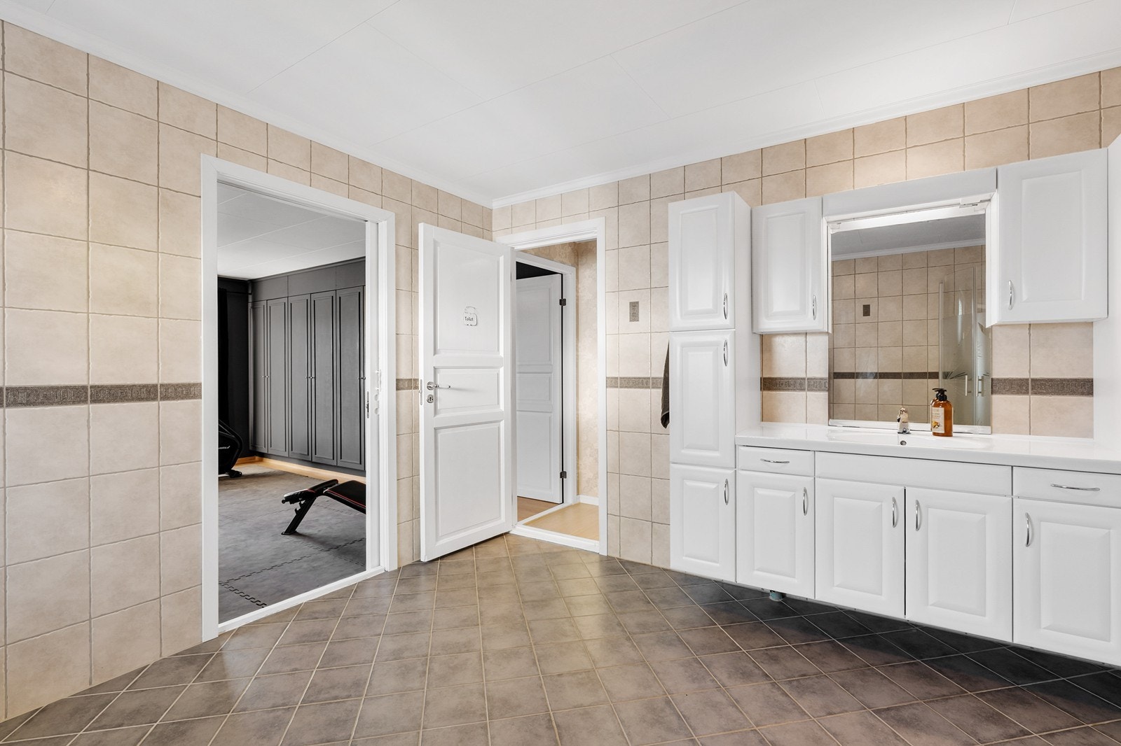 Det er også et romslig og helfliset bad ved trimrom Galleribilde