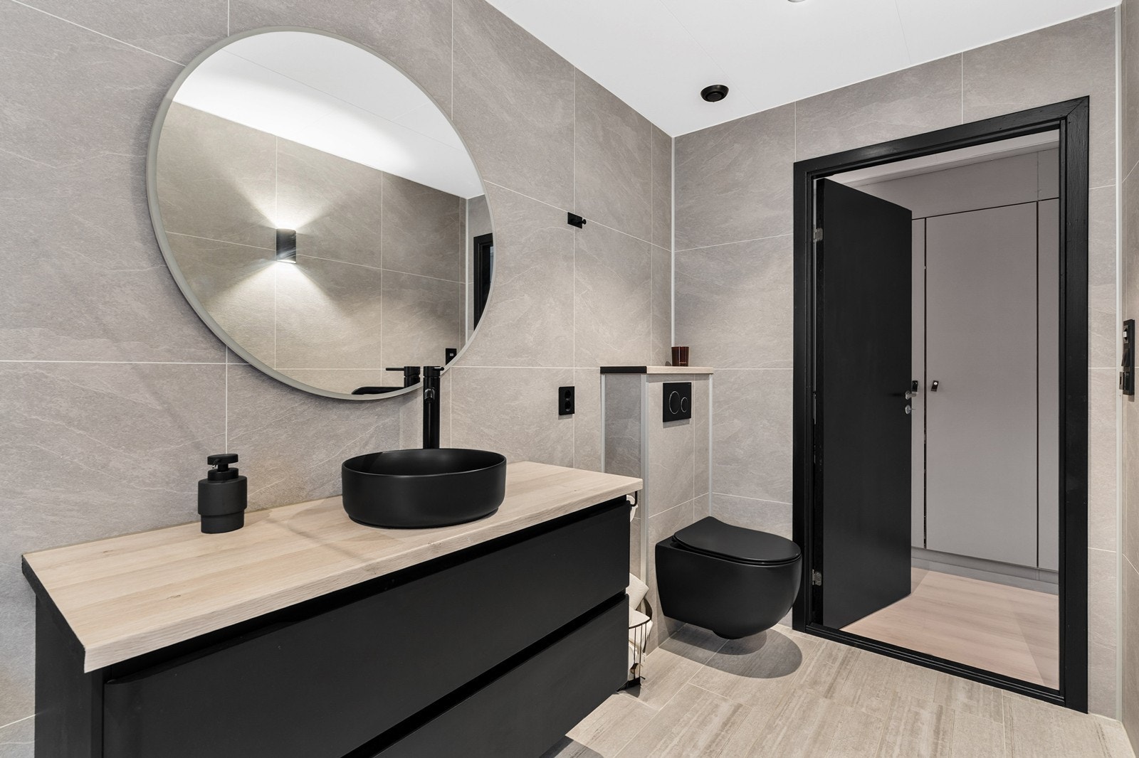 Badet er innredet med dusjvegger i glass, servant og vegghengt toalett. Badet er knyttet til soverom. Galleribilde