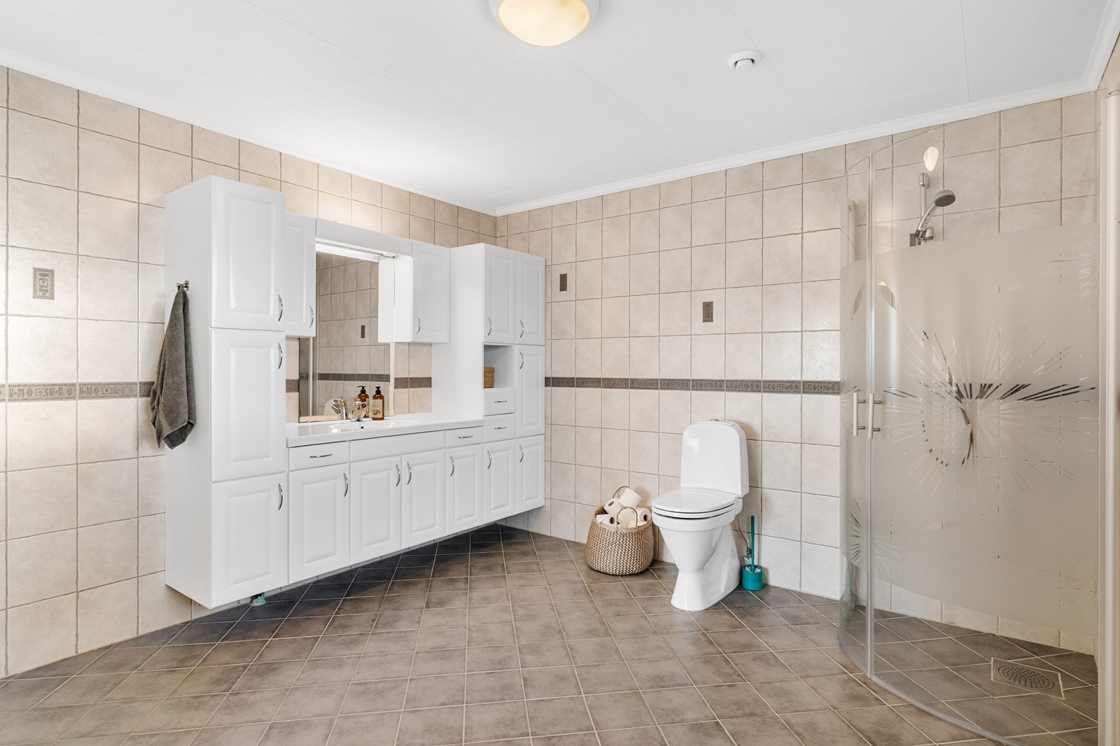 Badet er utstyrt med toalett, dusjhjørne og servantskap Galleribilde