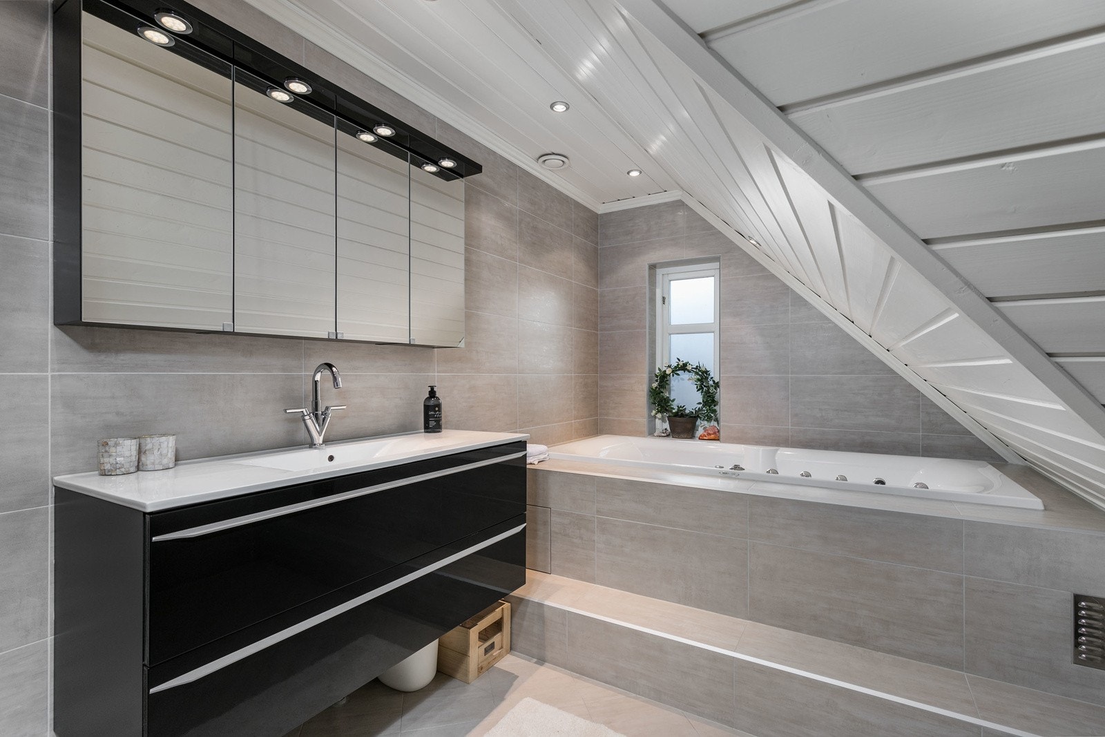 Delikat bad i loftsetasje, fra 2010 iflg. eier. Lekker baderomsinnredning bestående av benkeskap med glatte fronter. Speil og belysning over servant. Galleribilde