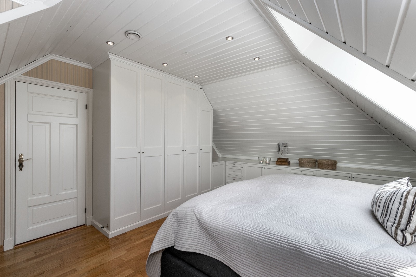 Meget flott plassbygget garderobeinnredning, samt skapinnredning som går langs veggen i rommet. Galleribilde