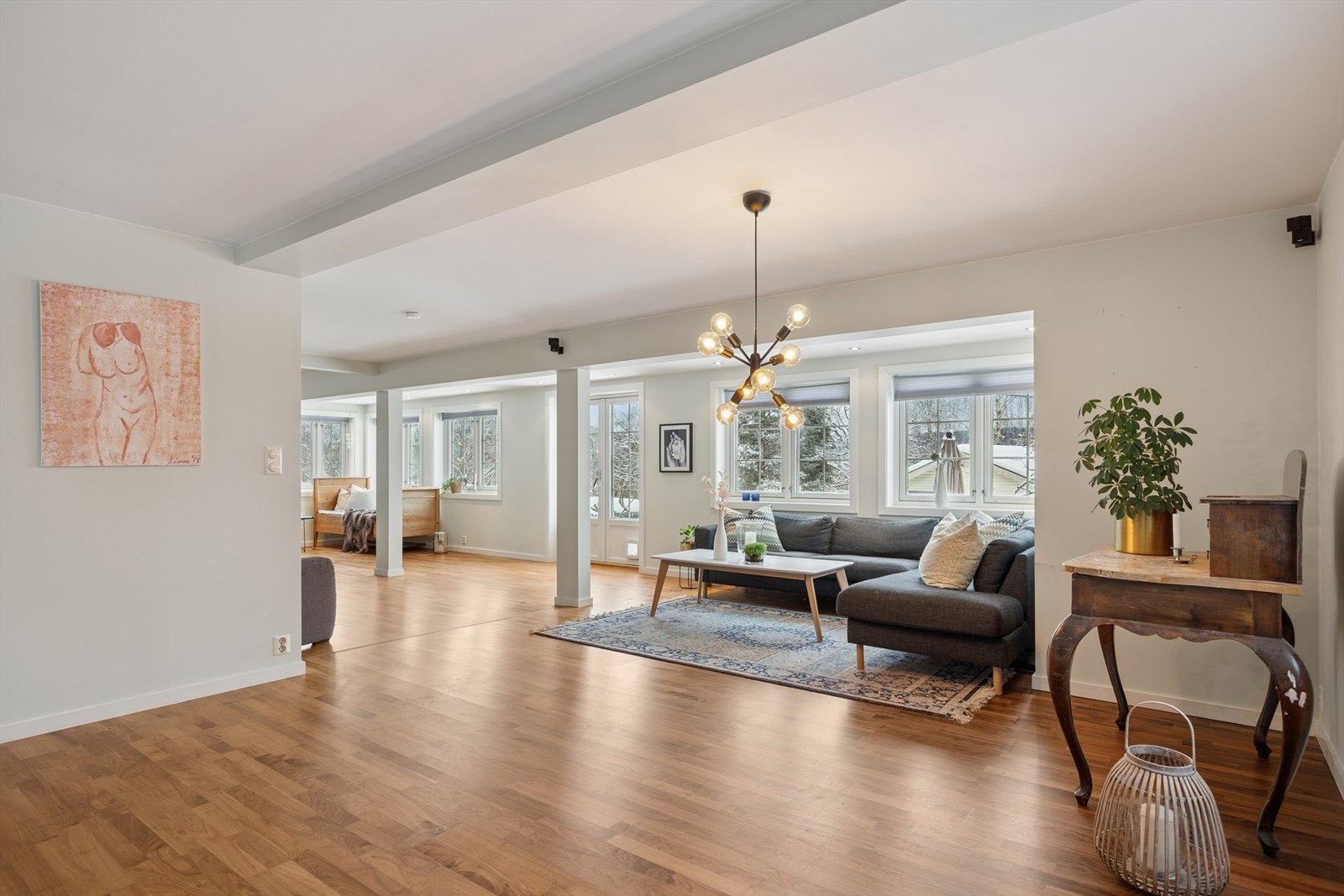 Den romslige stuen i første etasje har en åpen løsning og gjennomgående parkett på gulvet. Galleribilde