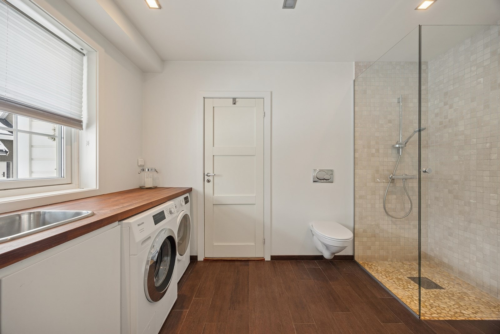 Rommet er flislagt med elektriske varmekabler i gulvet og har praktisk opplegg for vaskemaskin. Galleribilde