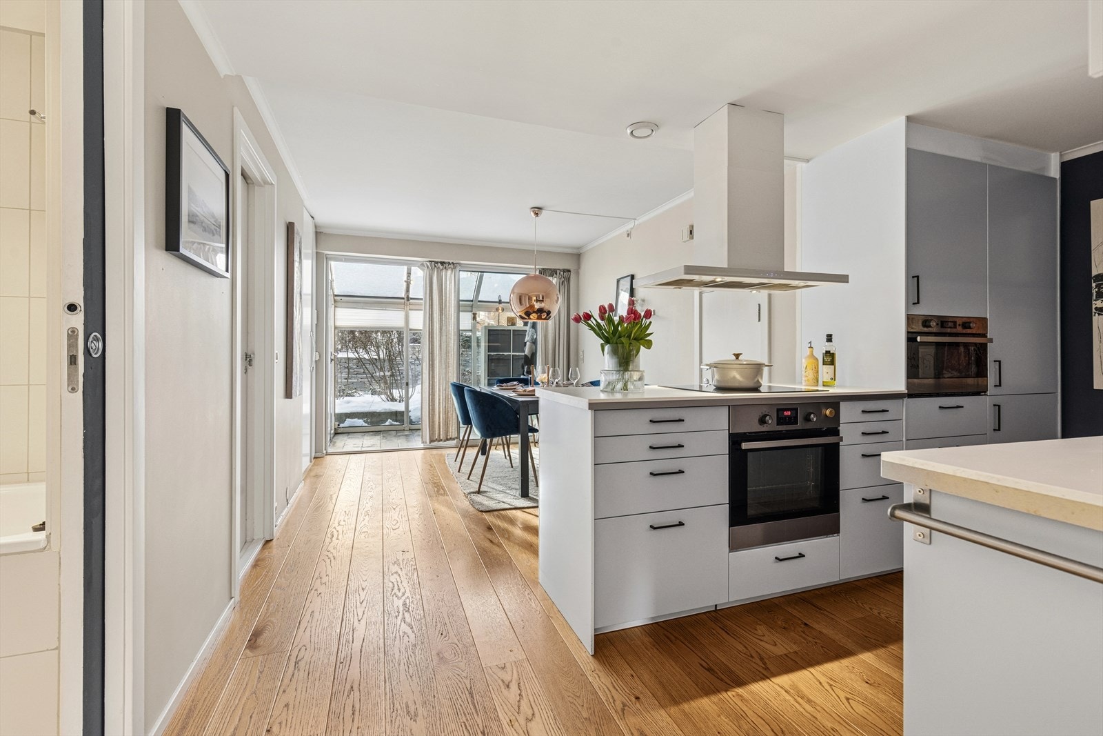 Fra kjøkkenet er det åpen siktlinje gjennom stuen og ut mot den store markterrassen. Galleribilde