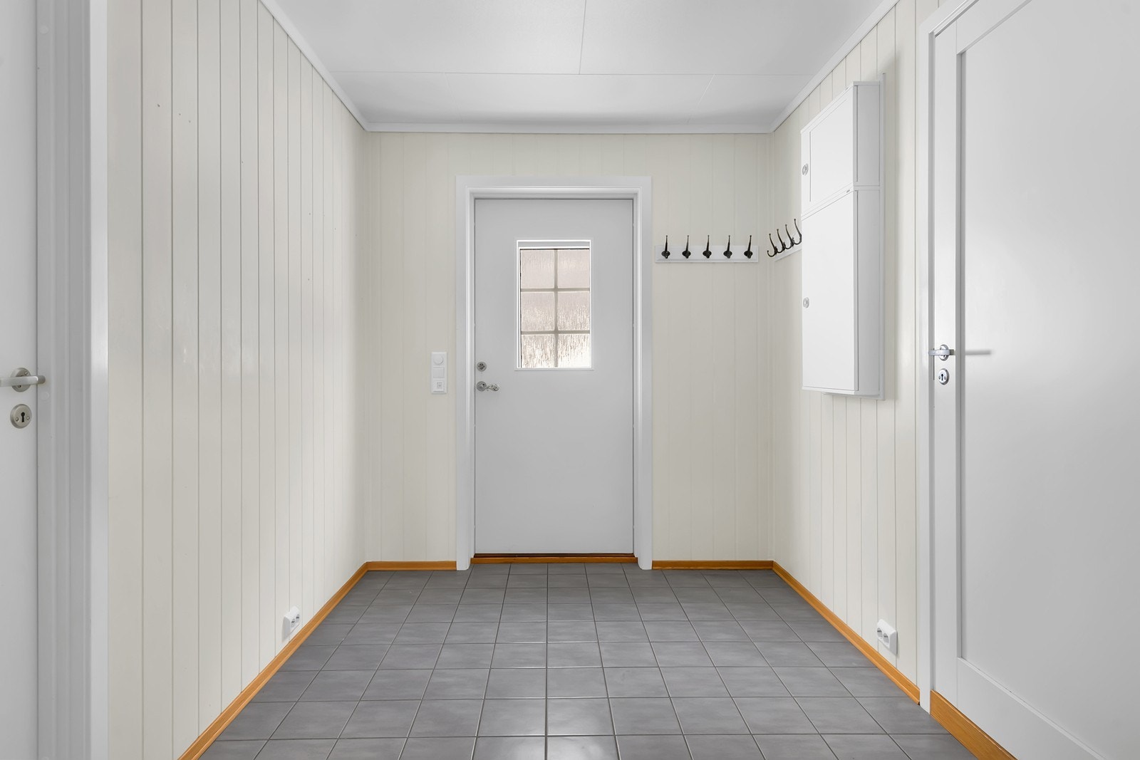 Praktisk entré med fliser på gulv og plass til oppheng av yttertøy. Galleribilde