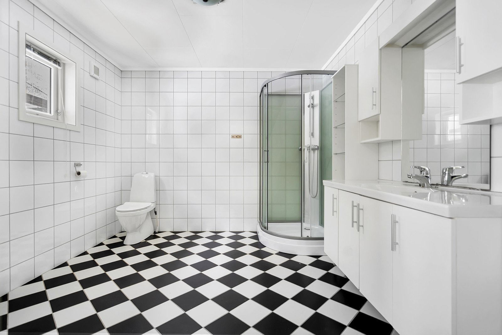 Bad med toalett, servant med oppbevaring og dusjkabinett. Galleribilde