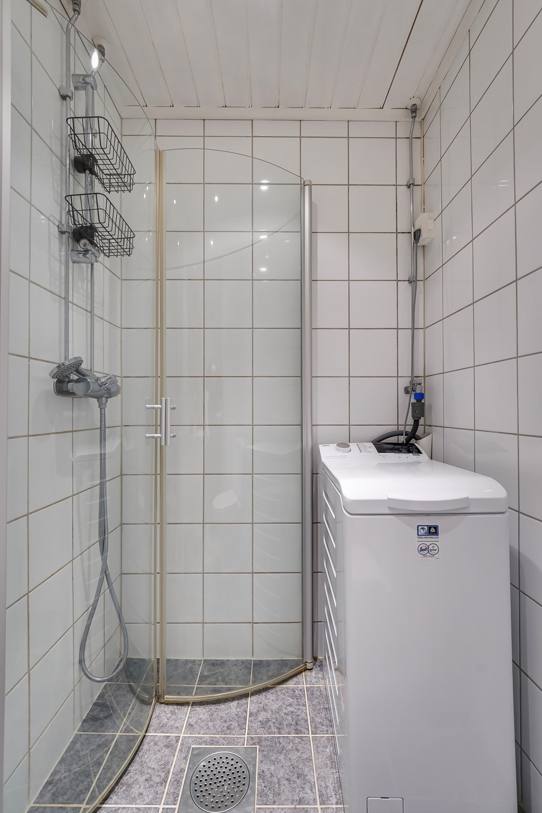 Praktisk dusjhjørne med innfellbare dusjdører. Badet har også opplegg for vaskemaskin, her er det plass til smal type. Galleribilde