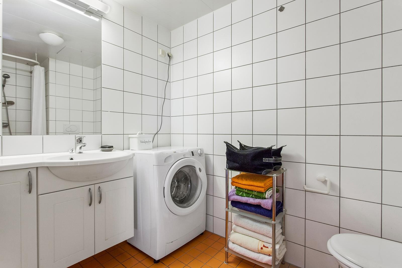 Flislagt bad med varmekabler og opplegg for vaskemaskin. Galleribilde