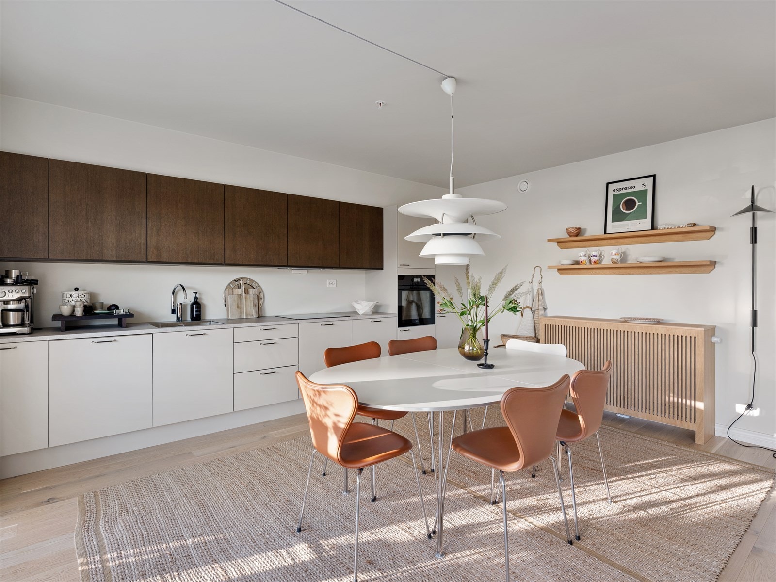 Vannbåren varme tilknyttet konvektor som er dekket med eikespiler og matchende hyller fra Austvoll tre & design. Galleribilde