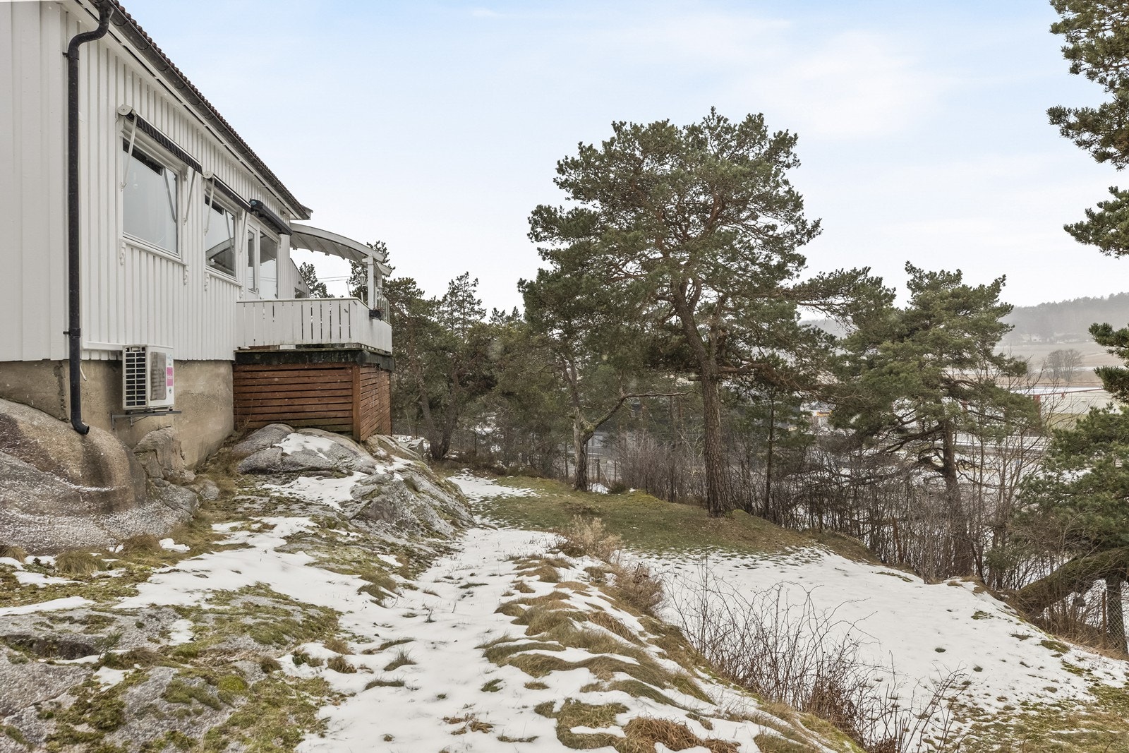Tomten er skrående med en kombinasjon av gressplen og naturtomt. Galleribilde