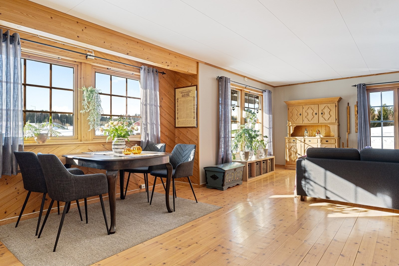 Gulvene i stuen er av tre, som gir en varm og innbydende atmosfære. Galleribilde