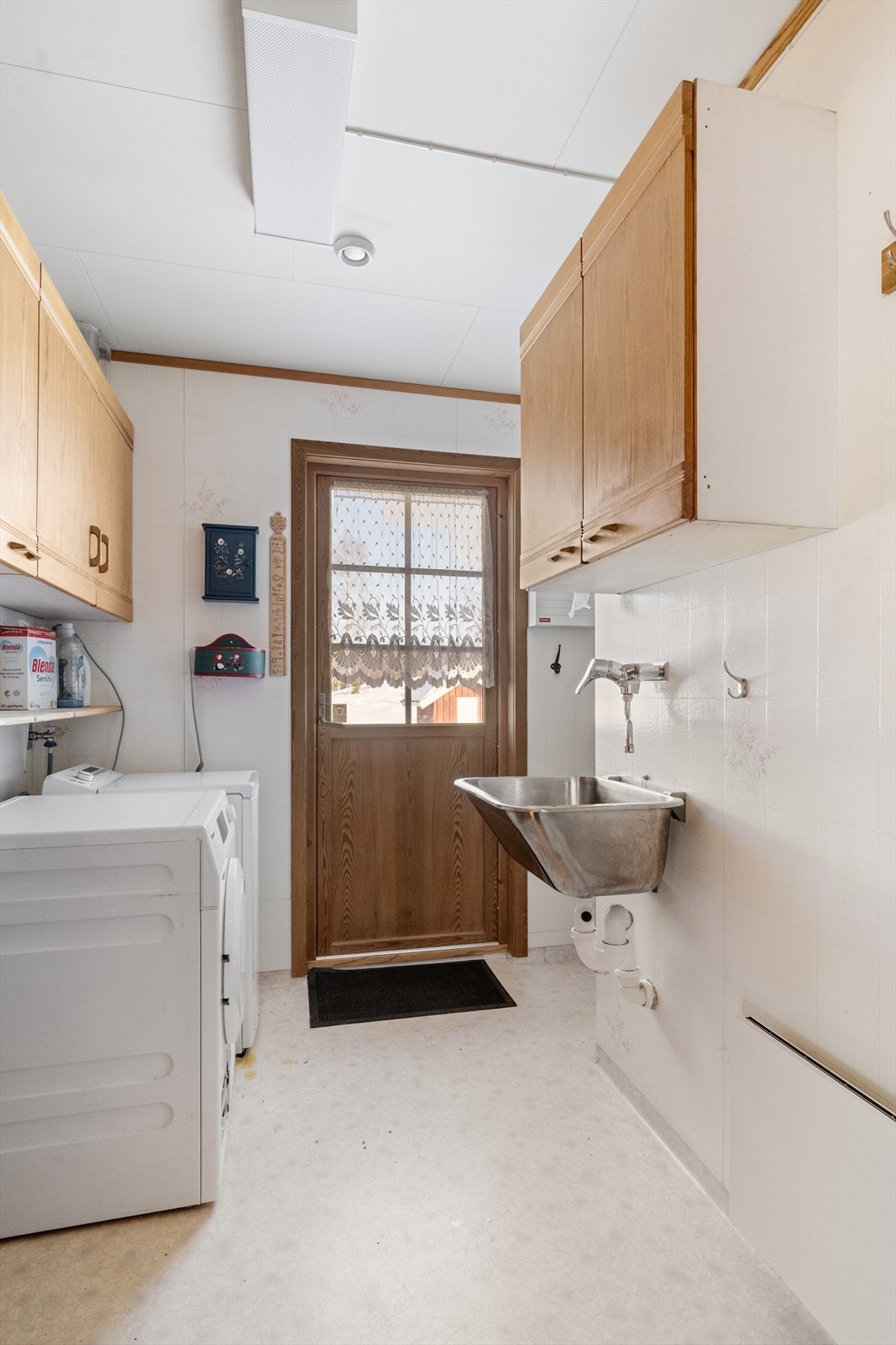 Praktisk vaskerom med utslagsvask og opplegg for vaskemaskin. Galleribilde