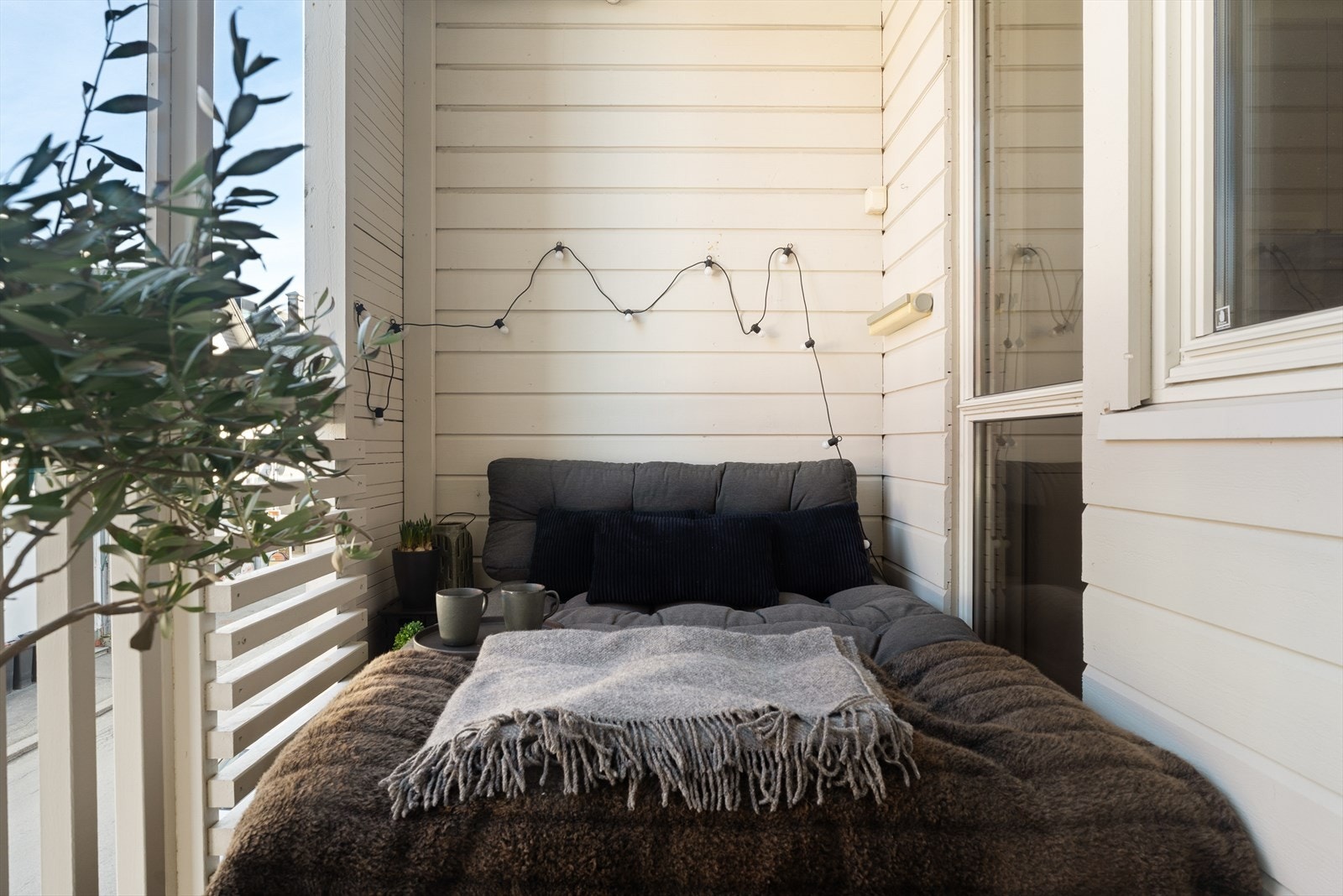 Balkongen har terrassebord og rekkverk i tre. Gulv/overflate ble beiset i 2025. Galleribilde