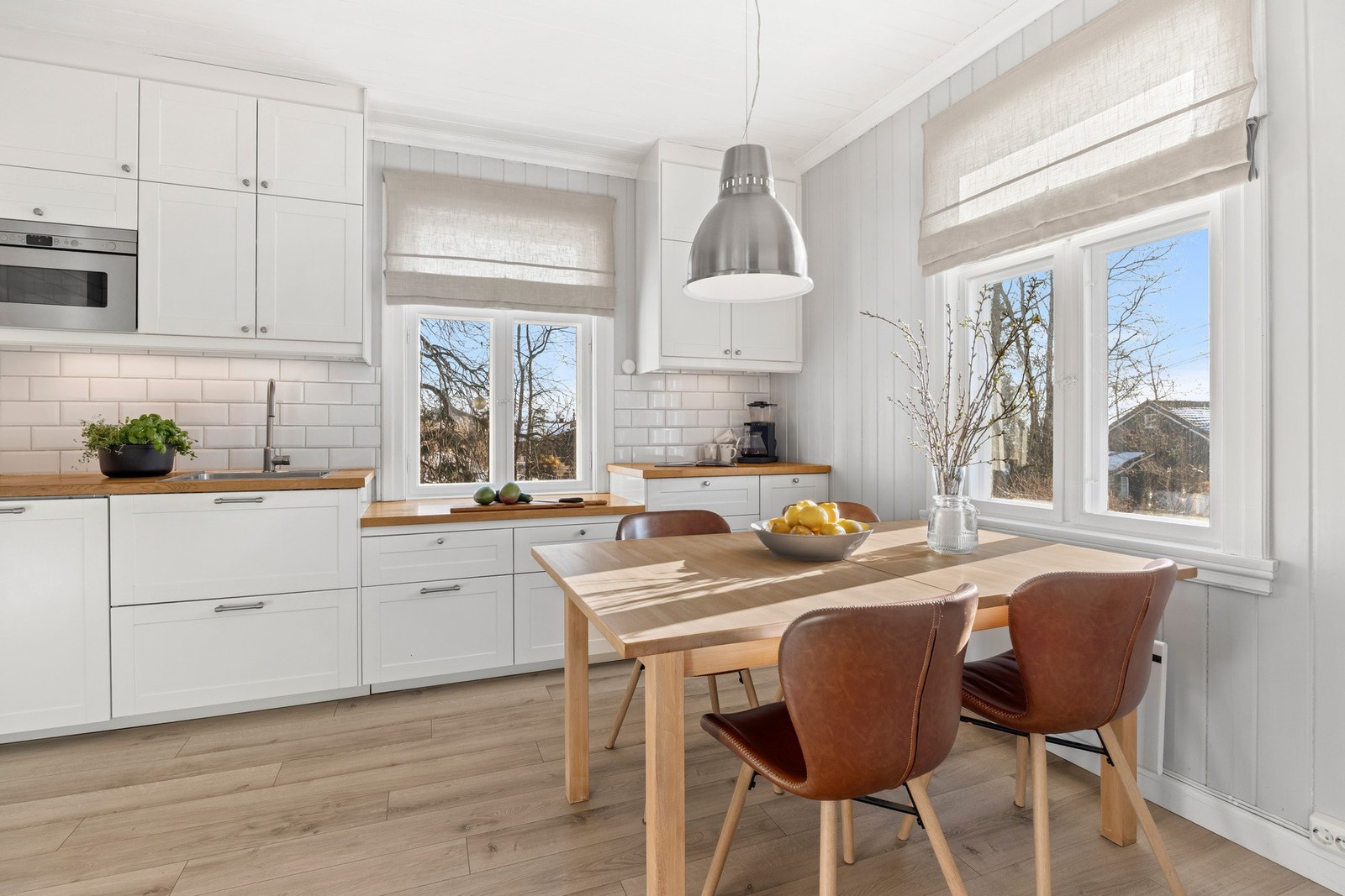 Lys og klassisk kjøkkeninnredning med profilerte fronter og heltre benkeplate. Galleribilde