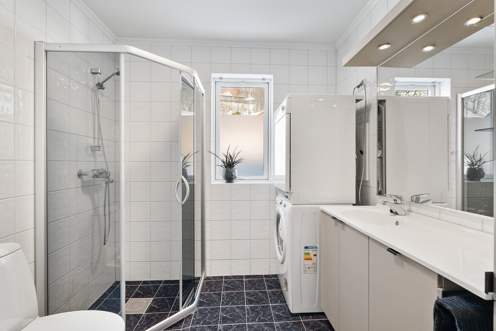 Badet har elektriske varmekabler i gulv, samt lys innredning i samme stil som kjøkkenet. Galleribilde