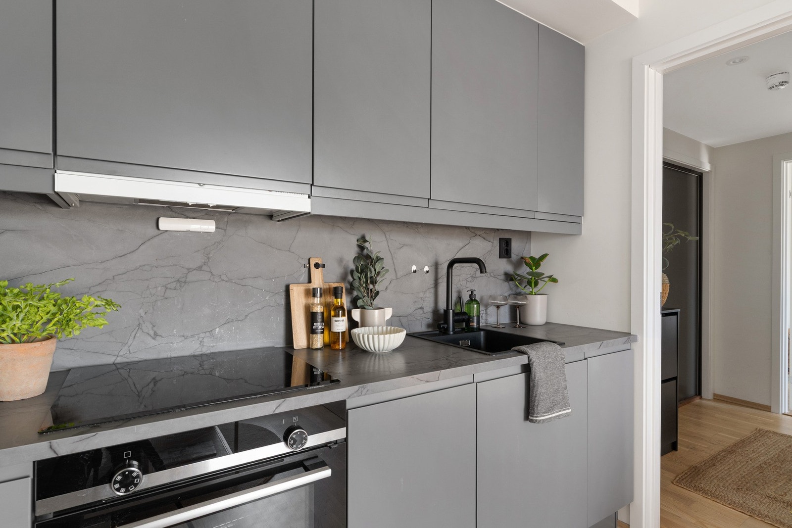 Moderne kjøkkeninnredning med induksjonstopp, komfyr og god skapplass. Galleribilde