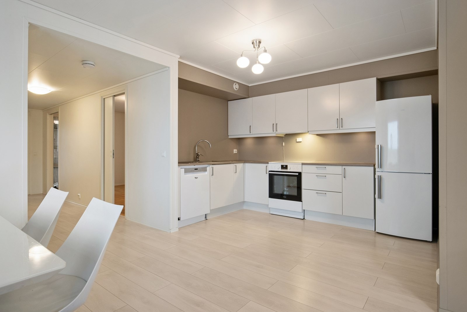 Kjøkkenet er praktisk innredet med hvite, slette fronter og god benkeplass. Galleribilde