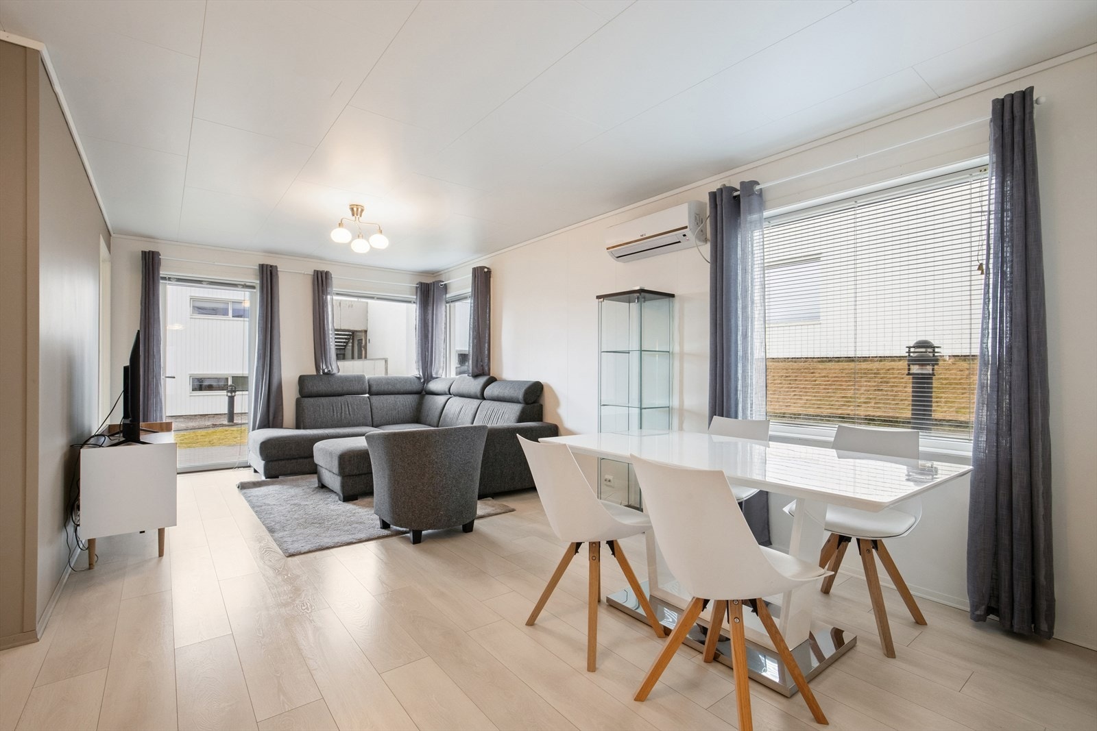 Stuen har god plass til både en komfortabel sofagruppe med TV-løsning og et stort spisebord der familie og venner kan samles. Galleribilde