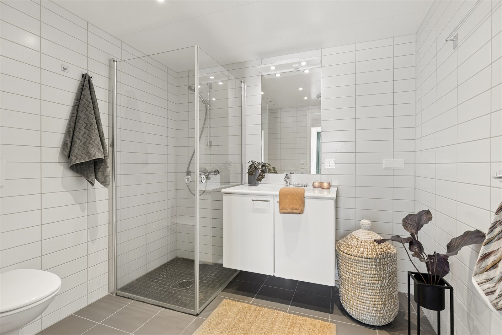 Delikat baderom fra 2020 med flislagte overflater, innfelt belysning og stilrene løsninger. Galleribilde