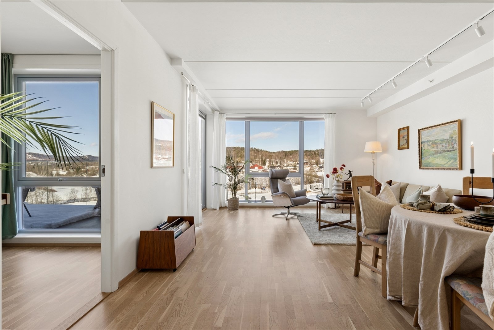 Den åpne løsningen binder stue, spisestue og kjøkken godt sammen, med store vindusflater som slipper inn dagslyset og skaper en behagelig atmosfære. Galleribilde