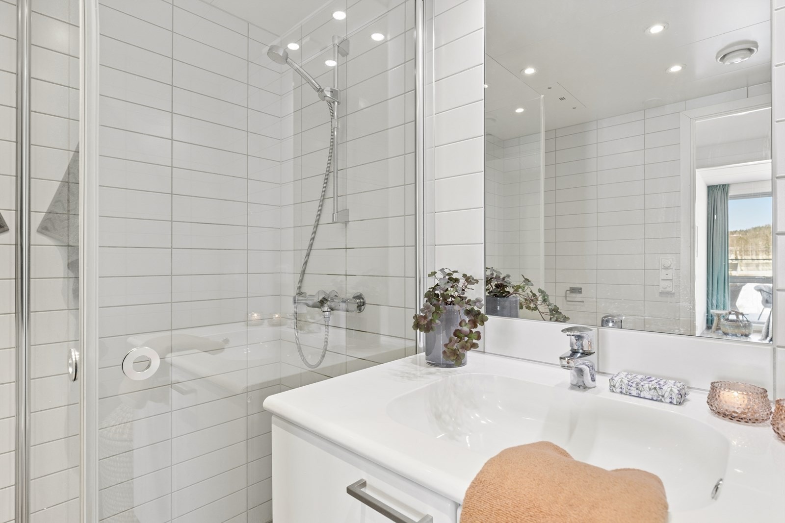 Moderne bad med dusjhjørne i glass, vegghengt toalett og opplegg for vaskemaskin - både praktisk og komfortabelt. Galleribilde