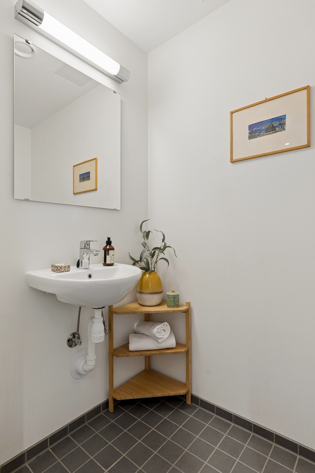 Elegant toalettrom med vegghengt toalett, stilren servant og moderne belysning. Galleribilde