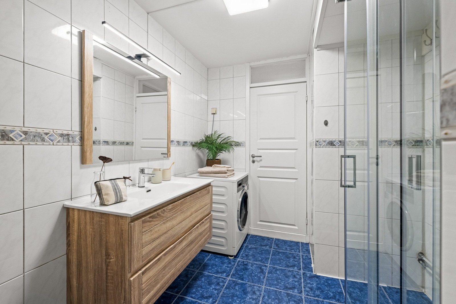 Badet er romslig og flislagt med praktisk dusjkabinett. Galleribilde