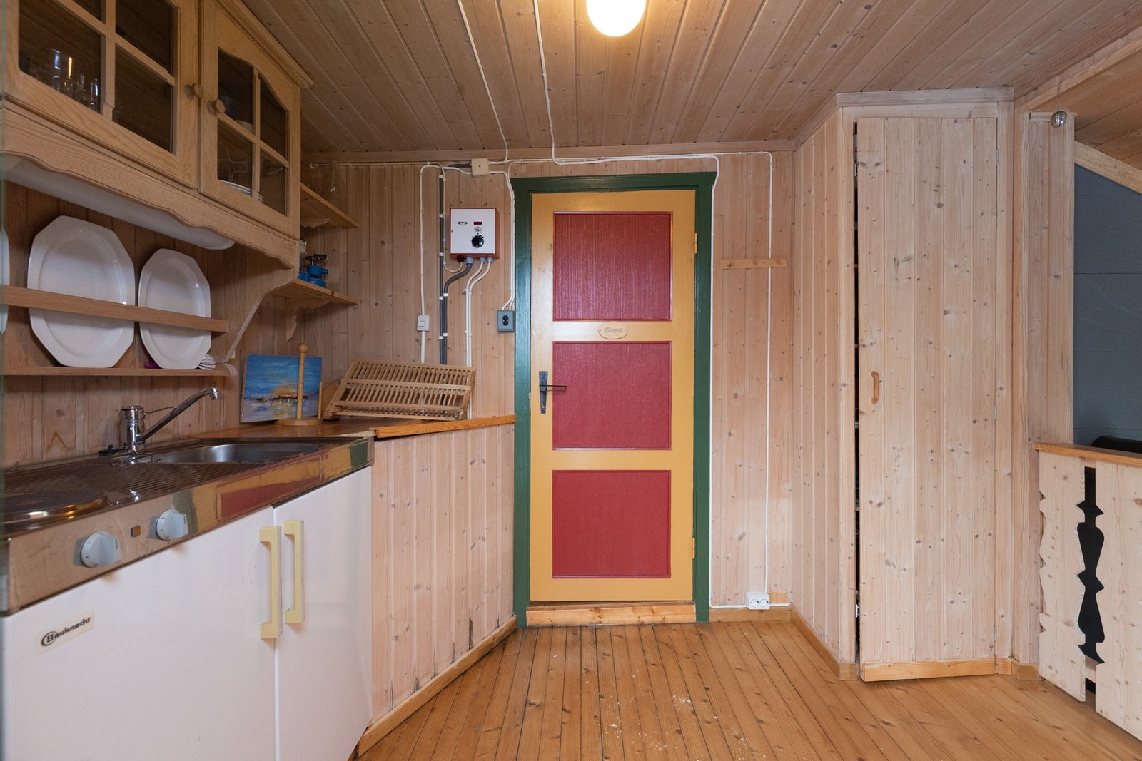 Kjøkkendelen byr på enklere kjøkkenfasiliteter med kran, koketopp og noe skapplass for oppbevaring Galleribilde