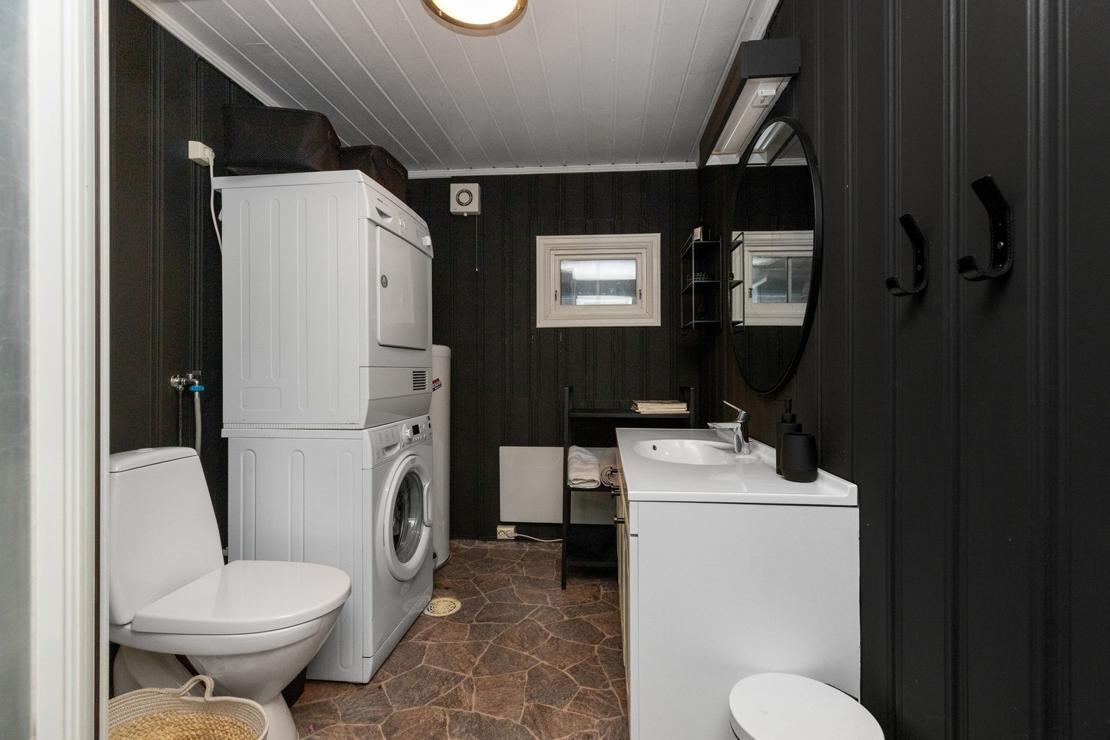 Badet har ellers servantskap med heldekkende porselensservant og gulvmontert vannklosett. Her er det opplegg for vaskemaskin og både vaskemaskin og tørketrommel medfølger salget. Galleribilde