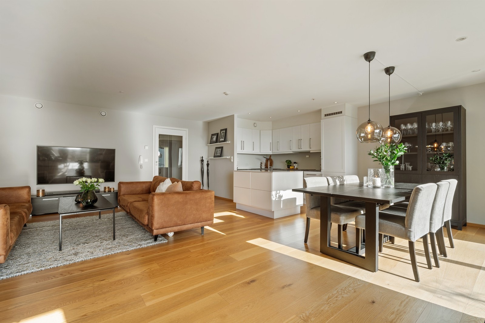 Praktisk åpen stue- og kjøkken løsning med naturlig sone for tv- og spisegruppe. Galleribilde