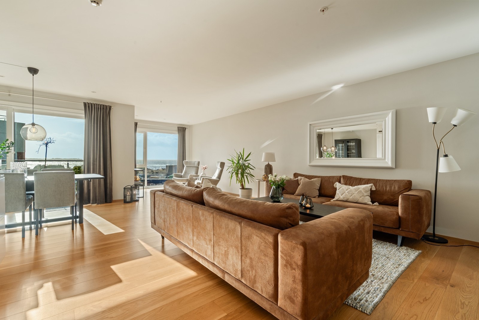 Stilren stue/kjøkken med listefrie overganger mot himling, downlights belysning og elegant én-stavs parkett. Galleribilde