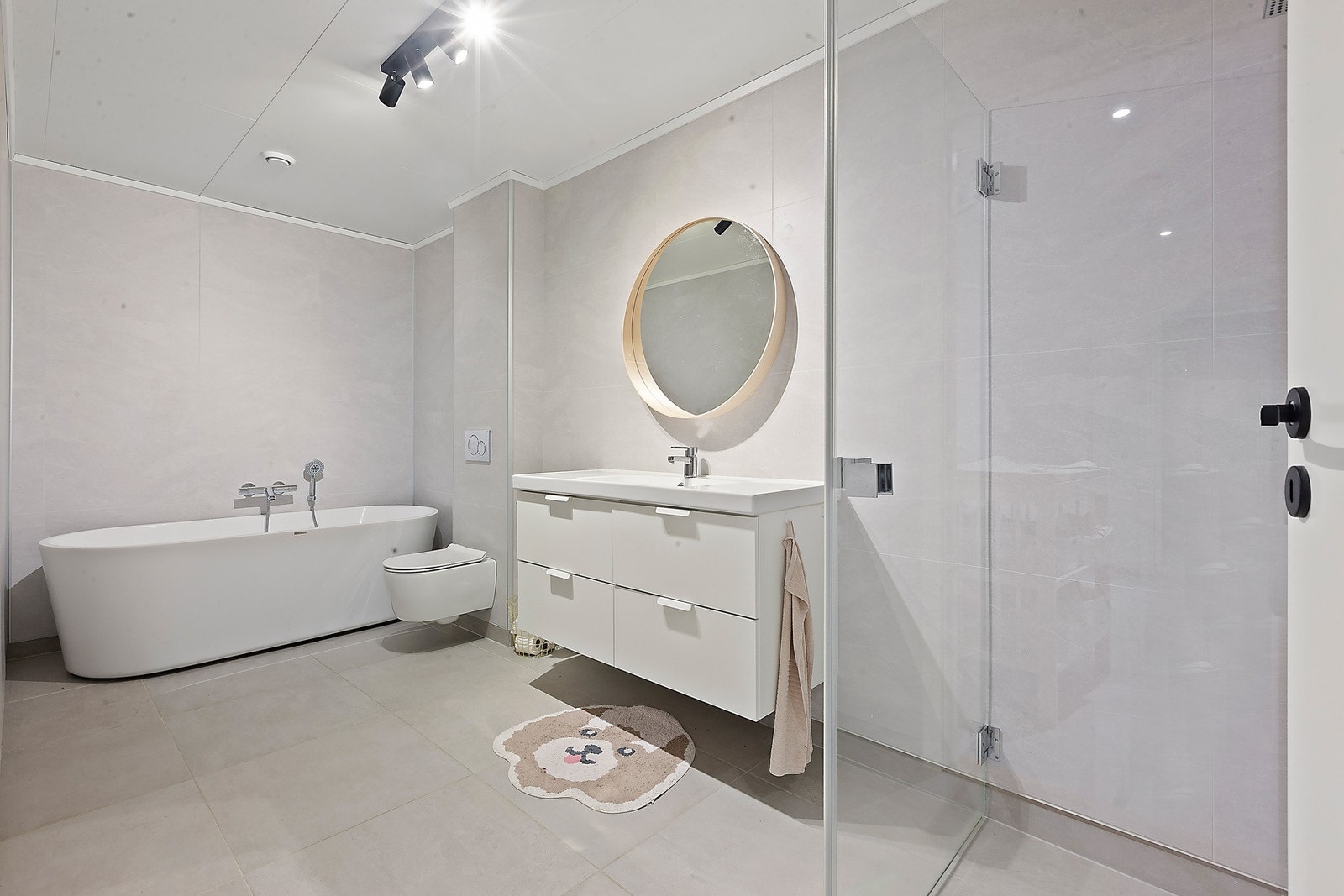 Delikat og lyst bad med moderne innredning, romslig badekar, separat dusjhørne, vegghengt toalett og komfortabel gulvvarme. Galleribilde