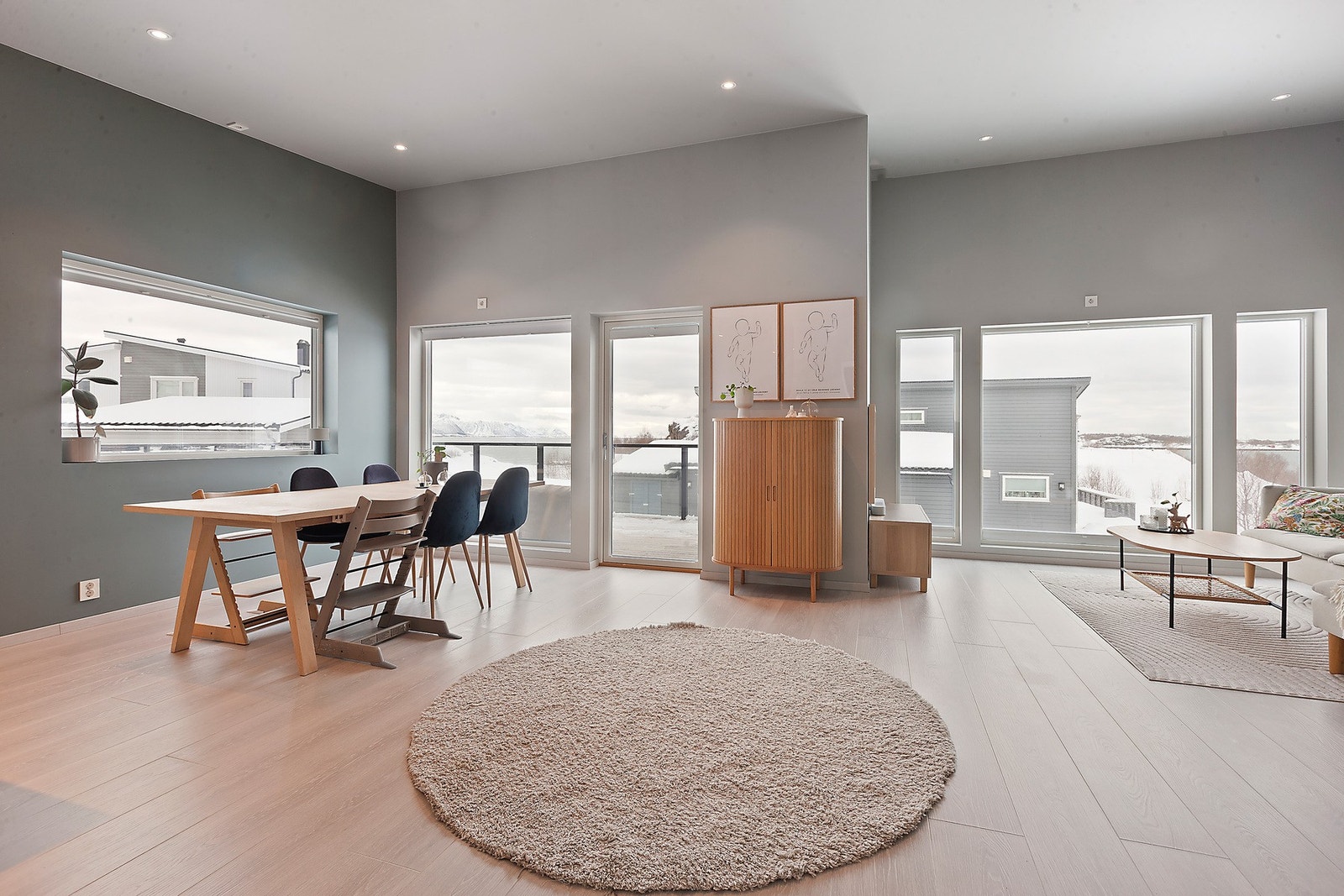 Innbydende stue med varme farger, spottbelysning og lysinnslipp som gir en lun og hyggelig stemning Galleribilde