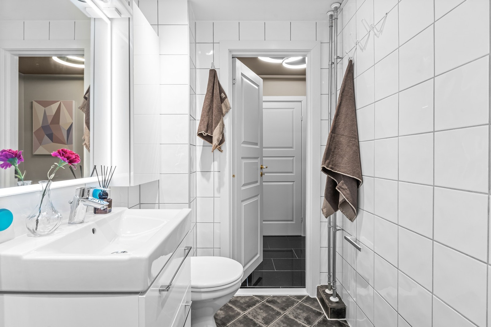 Servantskap med glatte fronter og heldekkende servant, samt gulvmontert klosett. Opplegg for vaskemaskin. Galleribilde