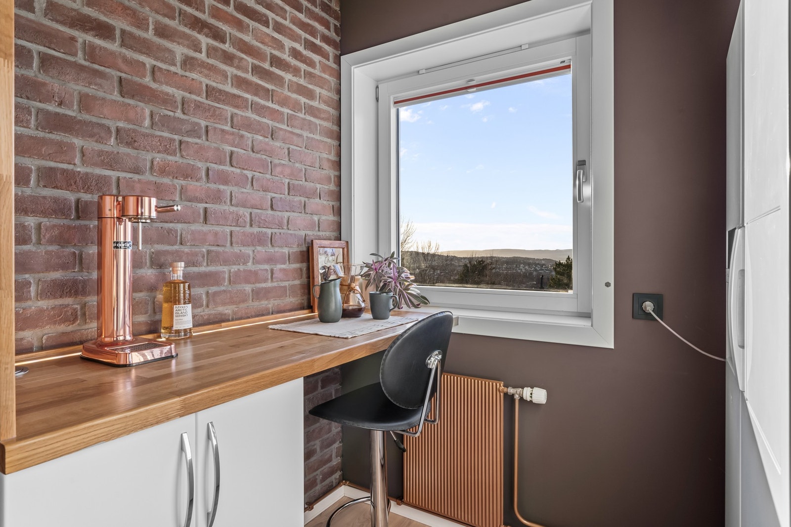 Deler av veggoverflater er kledd med fliser lignende teglstein, som gir et stilfullt særpreg. Her er også radiatorer og rør grunnet og lakkert i lekker kobberfarge. Galleribilde