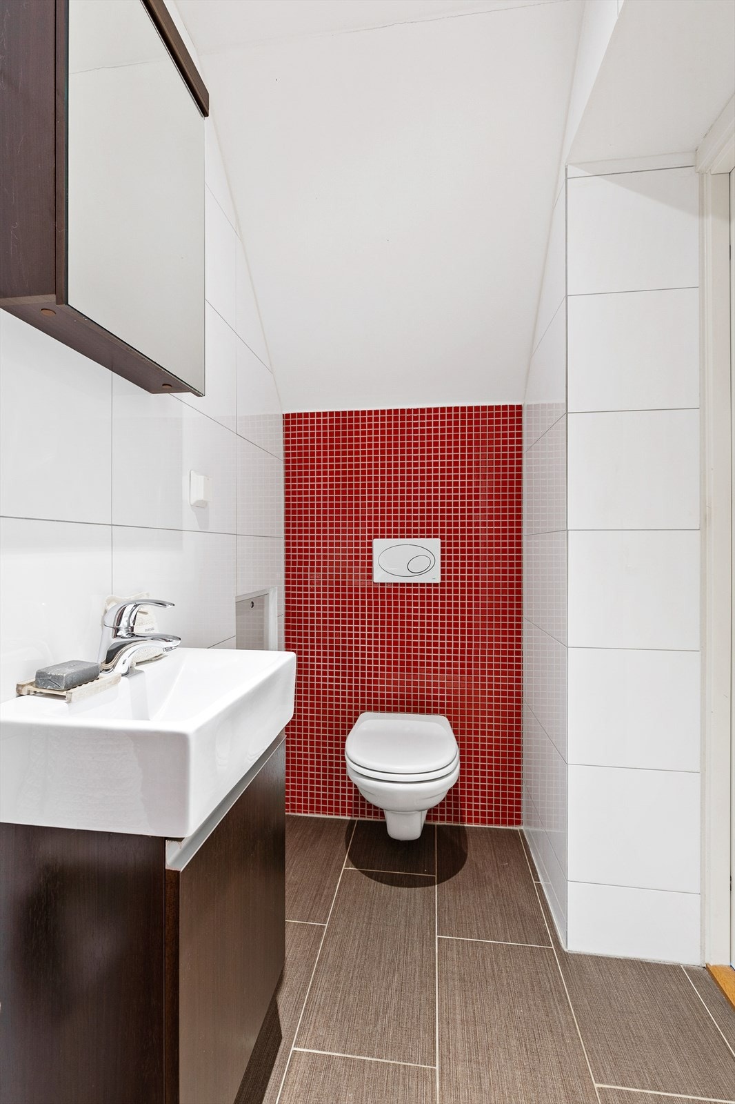 Badet er utstyrt med vegghengt toalett og servantskap med glatte fronter. Galleribilde