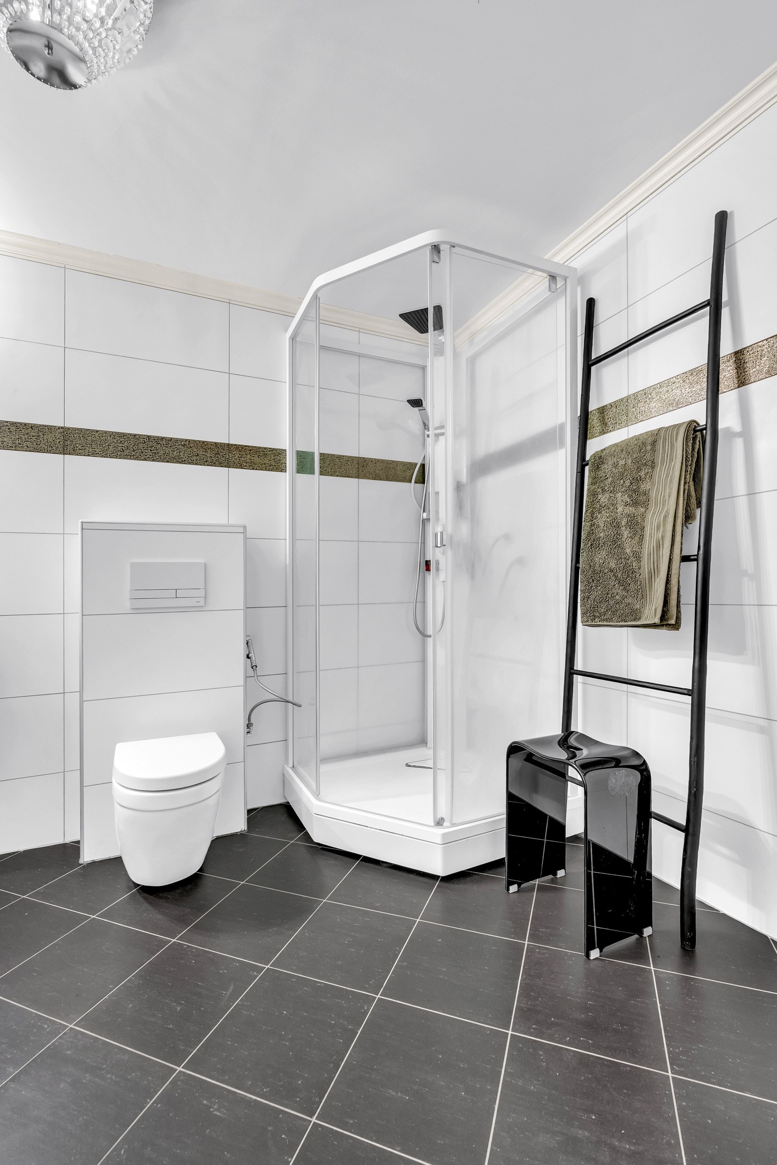 Badet er helflislagt med vegghengt toalett og dusjkabinett Galleribilde