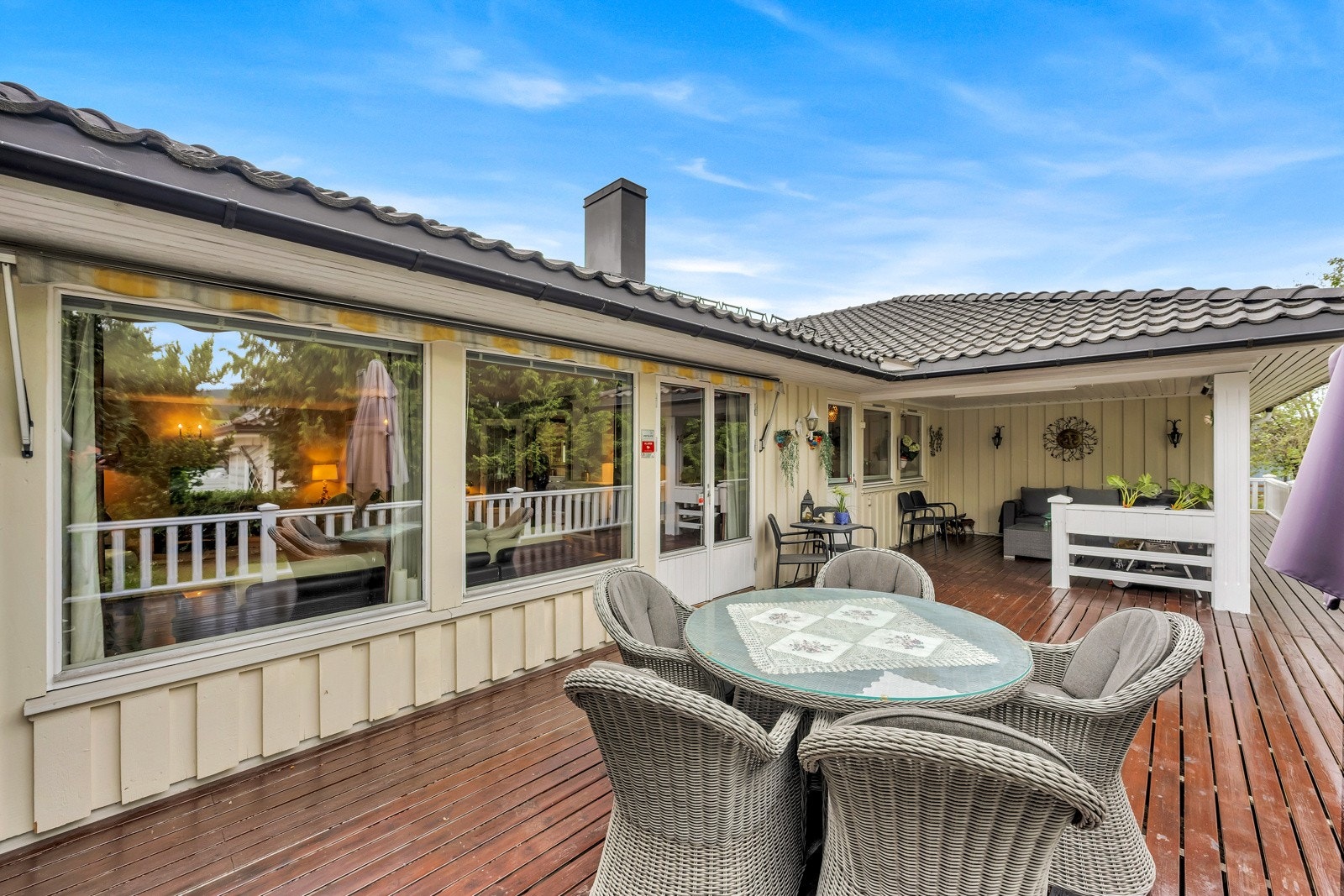 Stor terrasse som strekker seg langs hele boligen mot hagen Galleribilde