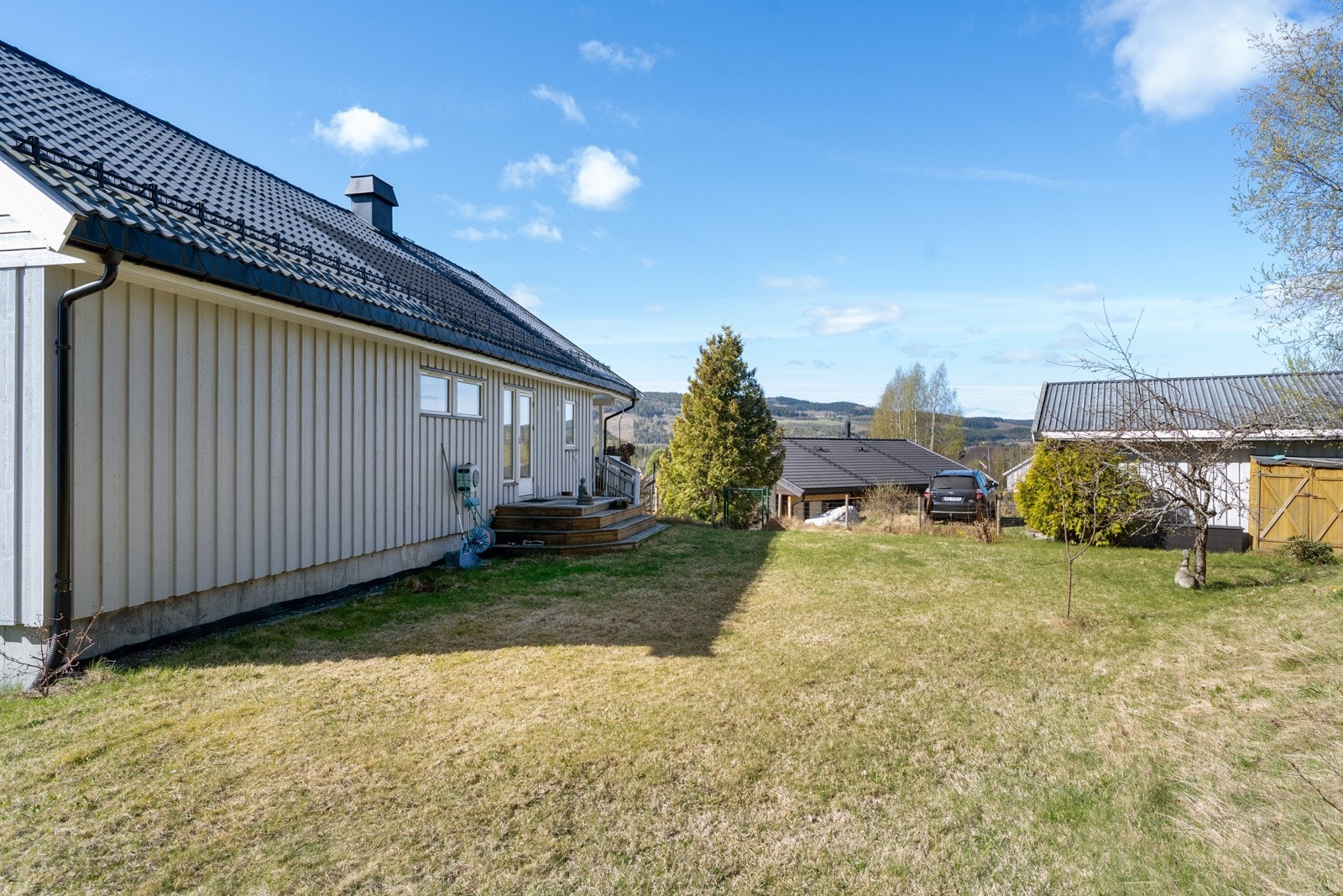 Tomten på ca. 1,4 mål er opparbeidet med plen, grus og diverse beplantning Galleribilde