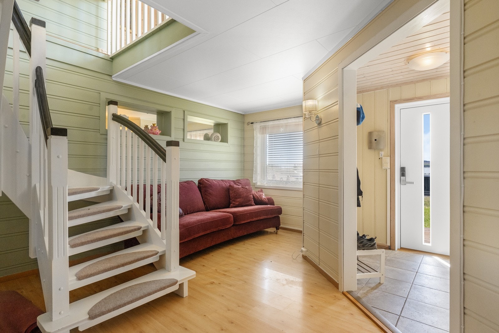 Boligens hovedinngang ligger i sokkeletasjen og ønsker deg velkommen med en lys og romslig entré med god plass til oppheng av yttertøy og oppbevaring av sko Galleribilde